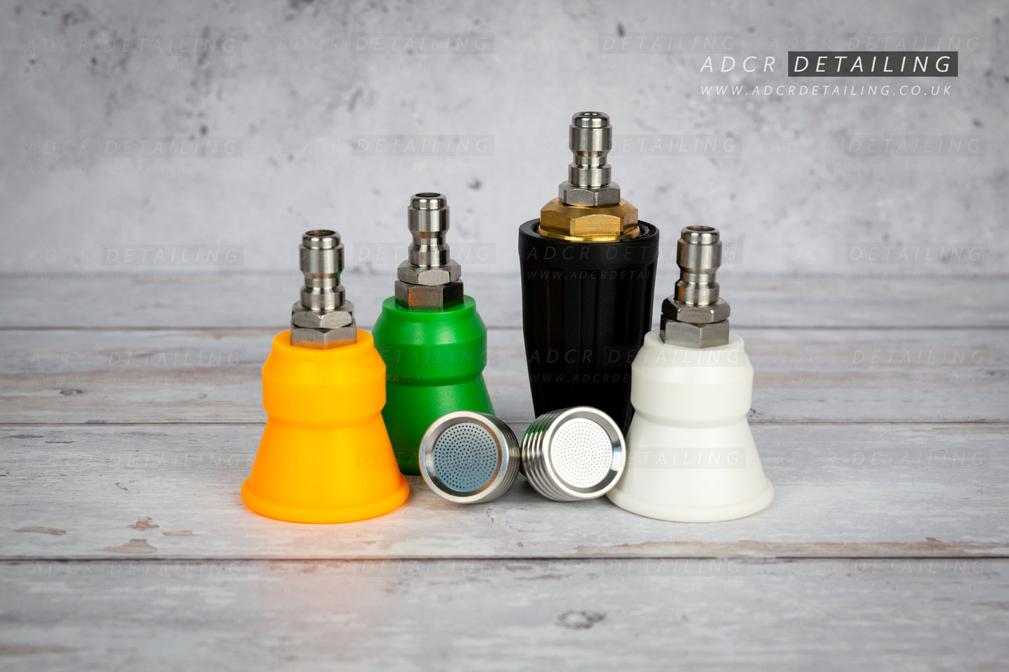 Collection of car detailing nozzles in various colours on a grey surface with 'ADCR Detailing' branding. Premium 1/4in Quick Release Nozzle Bundle. Shower Nozzles, 40 degree, 15 degree, 25 degree and turbo jet nozzle.