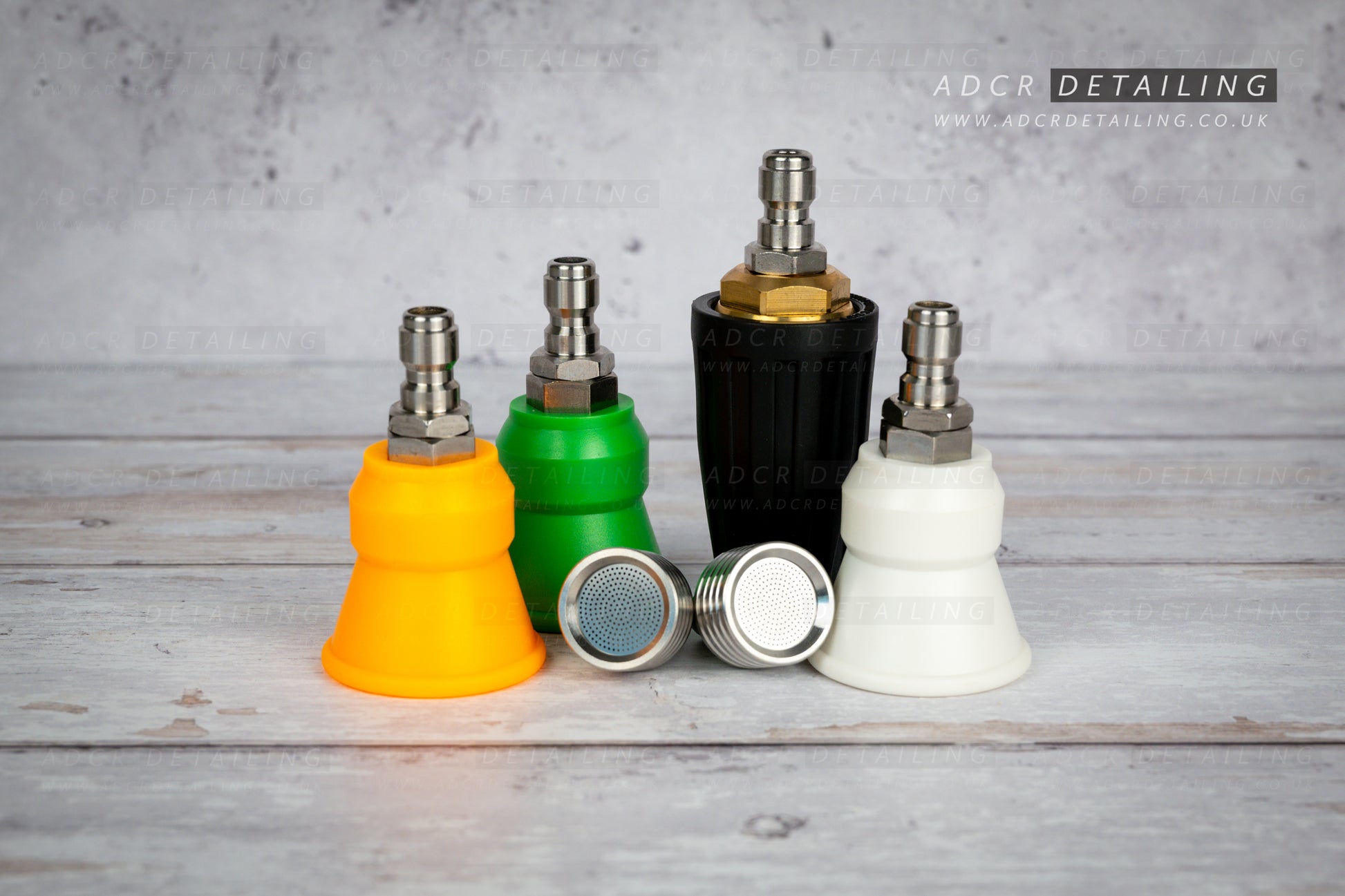 Collection of car detailing nozzles in various colours on a grey surface with 'ADCR Detailing' branding. Premium 1/4in Quick Release Nozzle Bundle. Shower Nozzles, 40 degree, 15 degree, 25 degree and turbo jet nozzle.