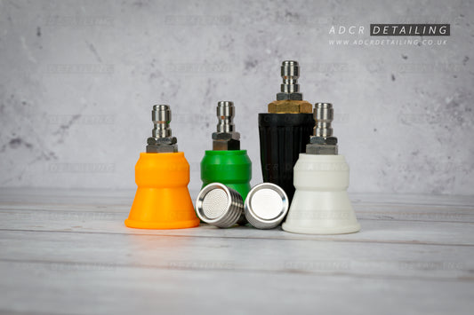Collection of car detailing nozzles in various colours on a grey surface with 'ADCR Detailing' branding. Premium 1/4in Quick Release Nozzle Bundle. Shower Nozzles, 40 degree, 15 degree, 25 degree and turbo nozzle.