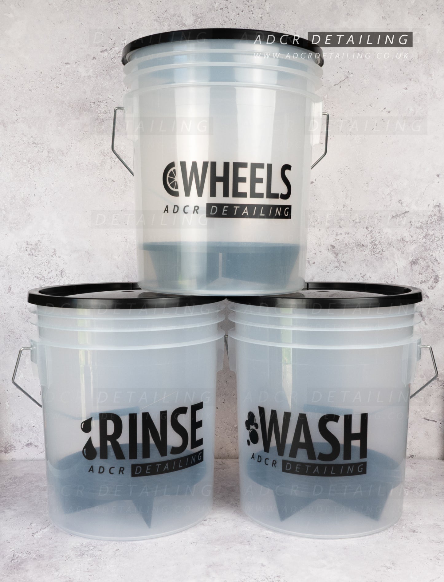 Three buckets labeled 'Wash', 'Rinse', and 'Detail' with 'ADCR Detailing' branding on a textured gray background.
