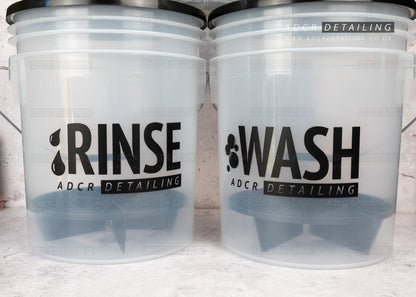 Two clear buckets labelled 'Rinse' and 'Wash' with 'ADCR Detailing' branding.