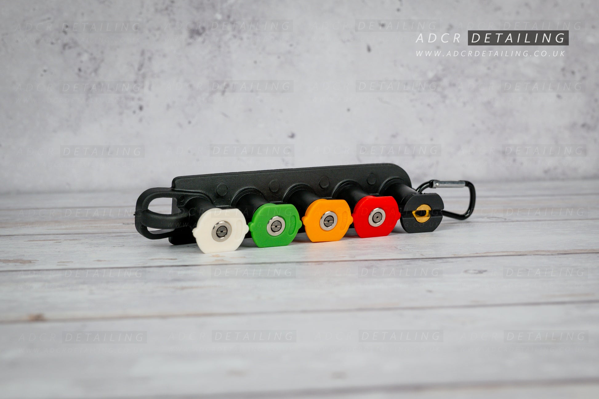 1/4in Quick Release Pressure Washer Nozzles in a black holder on a grey surface, featuring ADCR Detailing branding.
