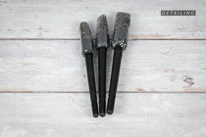 Three black car detailing brushes on a light wooden surface with 'ADCR Detailing' logo.
